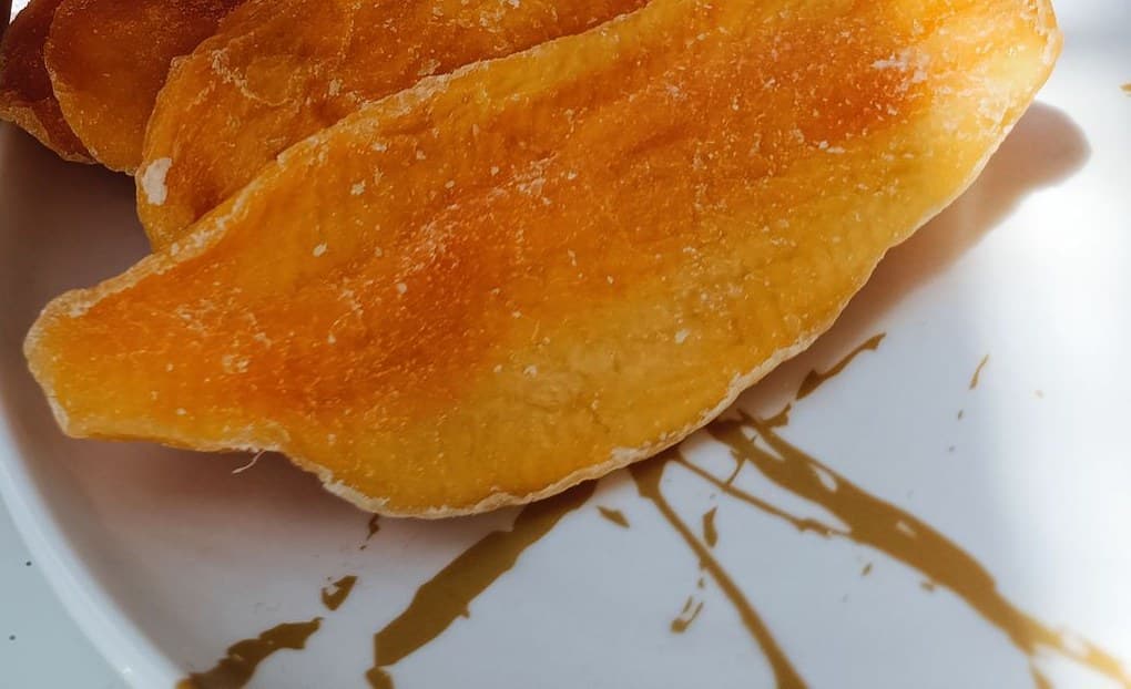 Close-up of soft dried mango slices with sugar crystals on the surface
