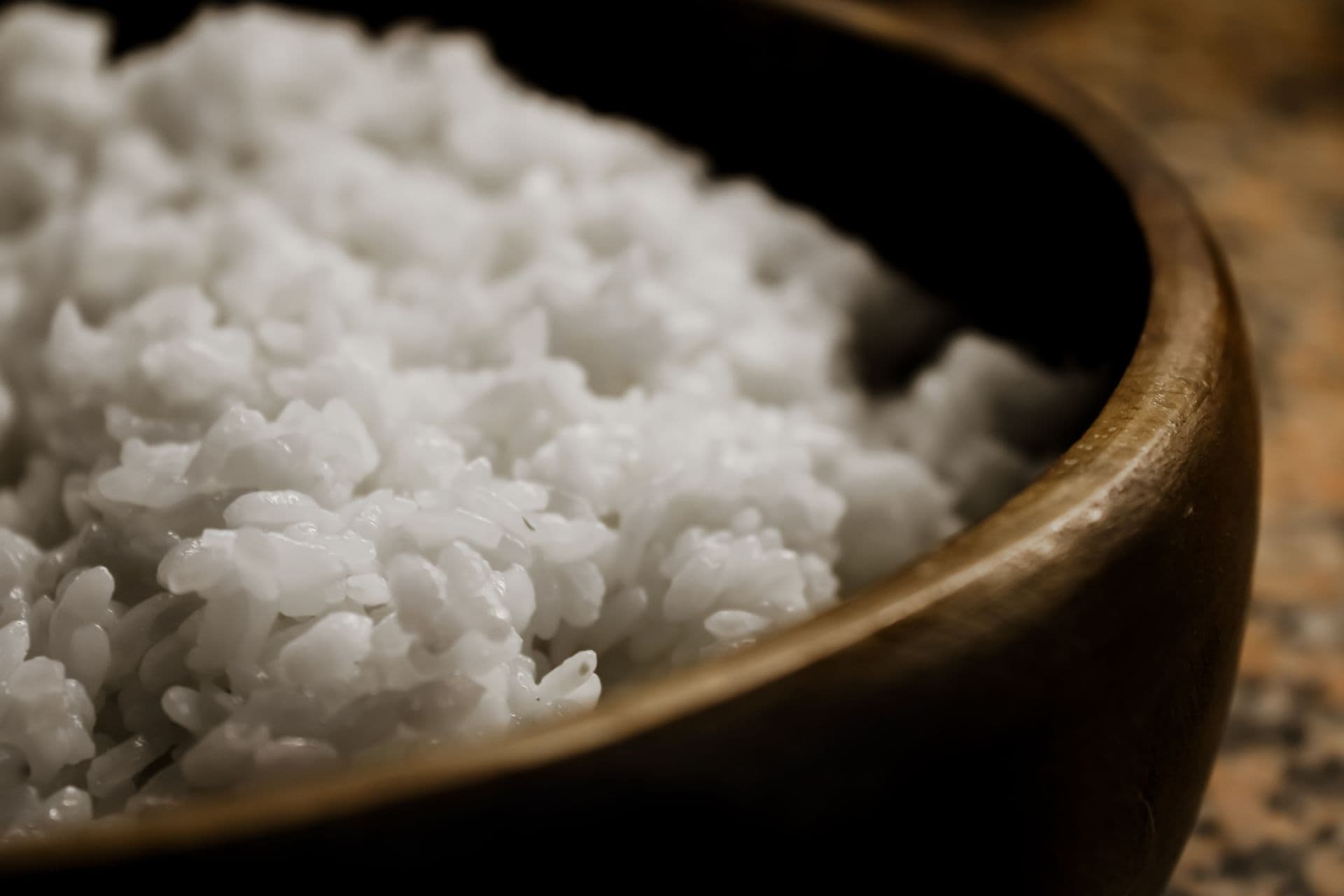 Cooked white rice in a wooden bowl